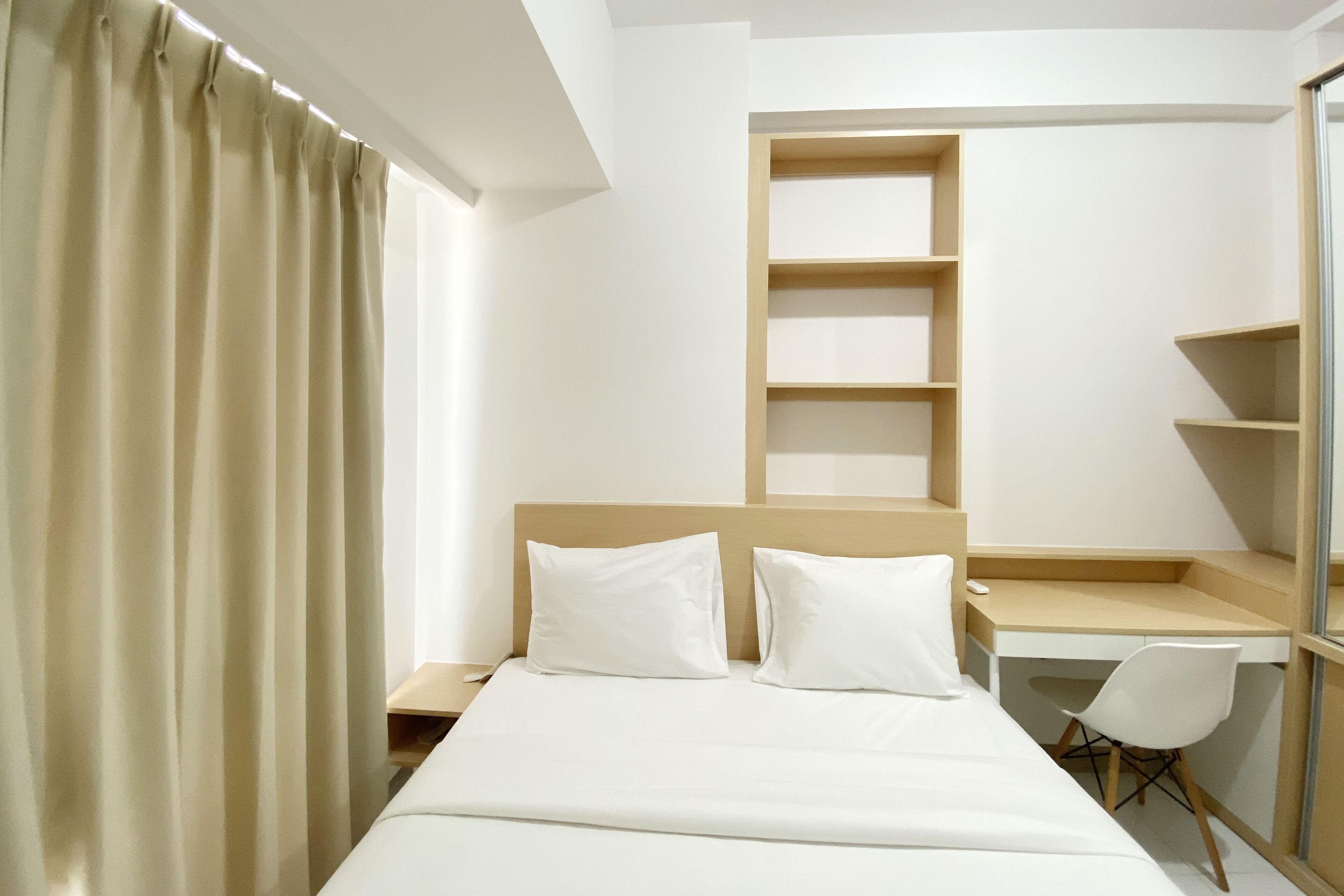 A hotel room with a bed, a desk, and a chair.
