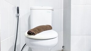 Bathroom features a toilet, shower, and towel.