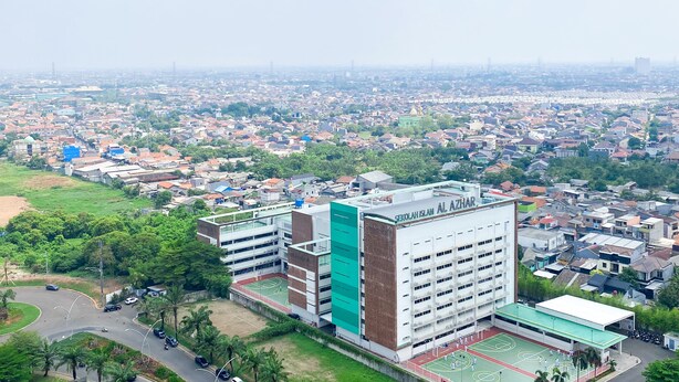A multi-story building with a sports court, surrounded by a residential area.