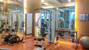 A gym with various exercise equipment, including treadmills, weight machines, and free weights. - Homey Penthouse 3Br With Extra Room Kemang Village Apartment (Jakarta)