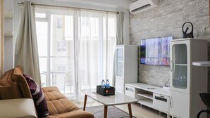 Una sala de estar moderna con un sofá, una mesa de centro, un televisor y un mueble.