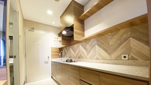 Een moderne keuken met houten kastjes, een backsplash met een herringbone patroon en een ingebouwde kookplaat.