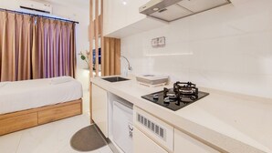 Una cocina compacta con lavabo, estufa y un refrigerador pequeño.