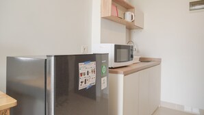 Eine Küche mit Kühlschrank, Mikrowelle und einer Holzhilfe.