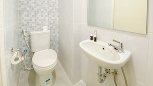 Ein Badezimmer mit Toilette, Waschbecken und Spiegel.