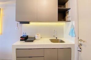Uma cozinha moderna com forno embutido, pia e bancada com dispensador de água e cafeteira.