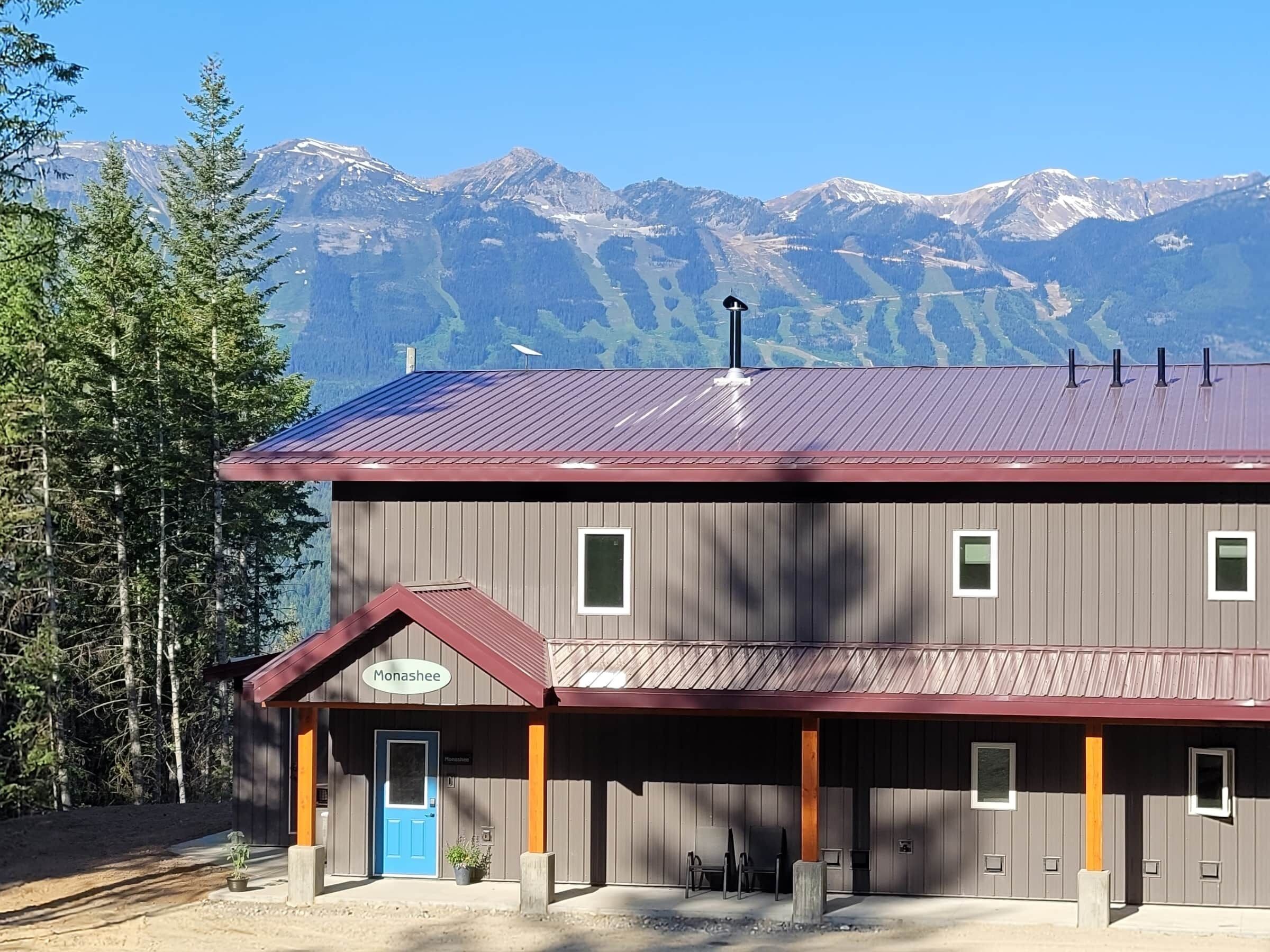 A wooden building with a blue door and a sign reading "Monashee."