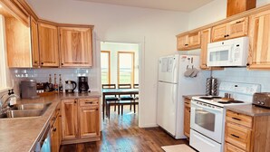 Una cucina moderna con mobili in legno, elettrodomestici in acciaio inossidabile e vista sull'area pranzo.