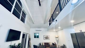 Une cuisine moderne dotée d’un plan de travail en marbre, d’un ventilateur de plafond et d’un coin repas avec une table et des chaises.