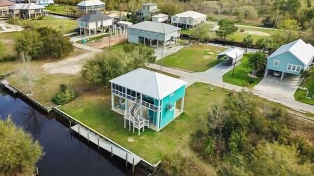 An aerial view of a residential area with houses, a dock, and a body of water. - Great Escape -2 Br 2Ba Waterfront Bay St Louis MS (Hancock County)