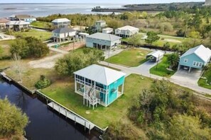 Vue aérienne d’un quartier résidentiel avec des maisons, un quai et une étendue d’eau.