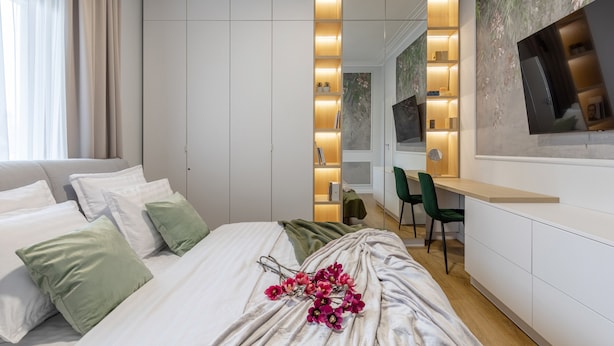 A modern bedroom with a bed, green and white pillows, a desk, and a TV. - Luxury Piata Romana 2BR Urban Sanctuary by HOLT (Bucharest)