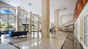 A spacious lobby with a marble floor, seating area, and a staircase leading to upper levels. - Spacious Beachfront Retreat,
Family Friendly,
Free parking/Free Public Trolley (Miami Beach)
