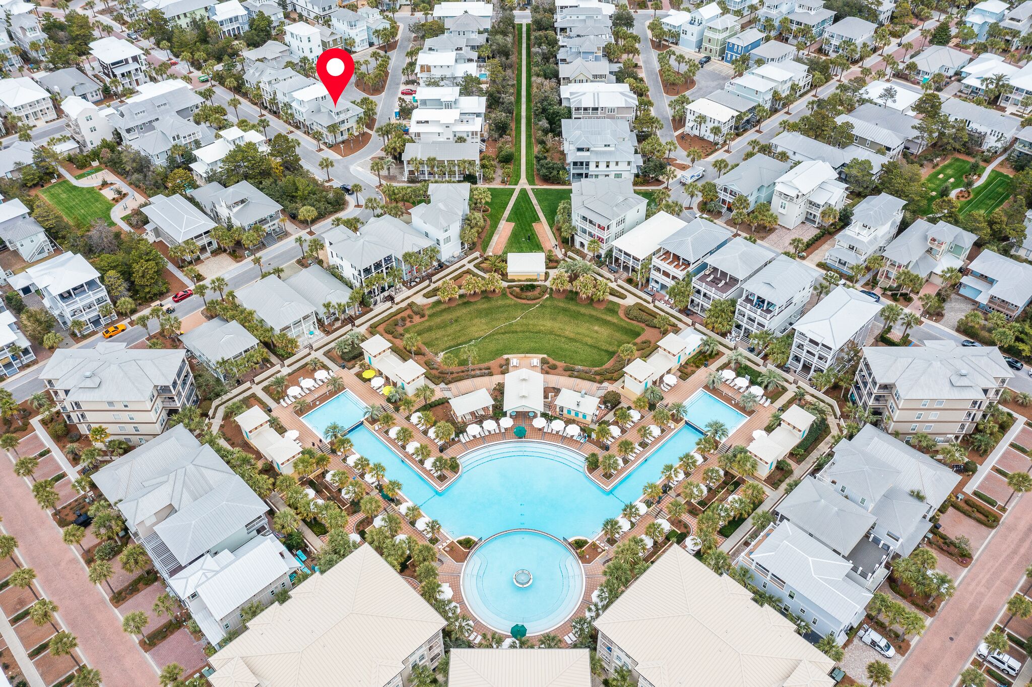 Vista aérea de una zona residencial con una piscina central rodeada de casas.
