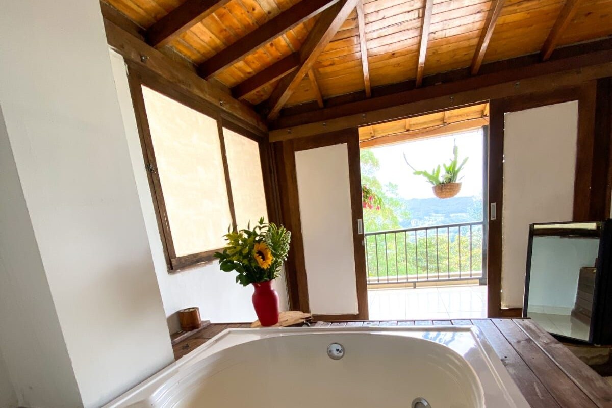 Ein Whirlpool in einem Zimmer mit Holzbalken und großen Fenstern.