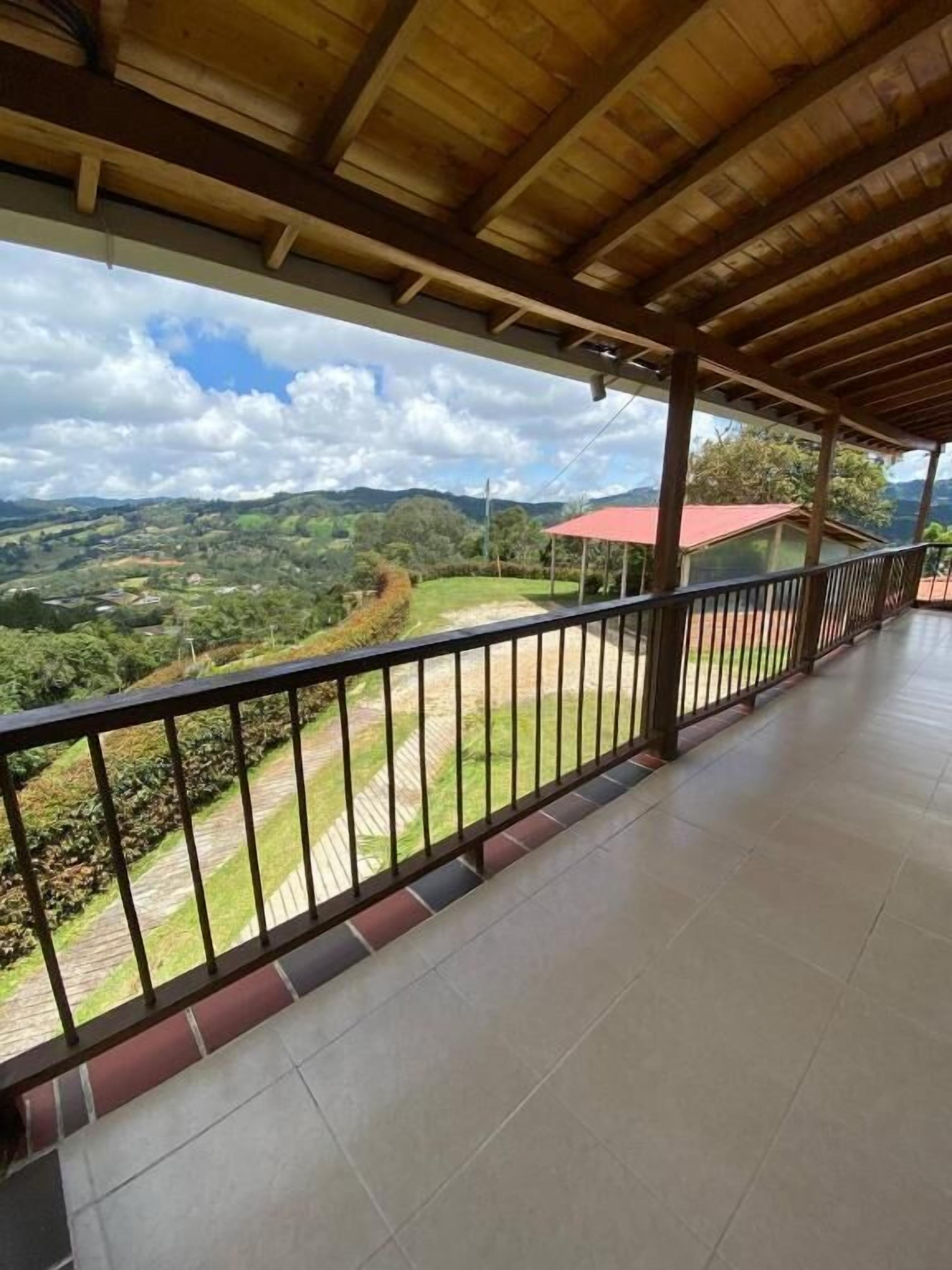 Un balcón techado con vistas a un paisaje montañoso.