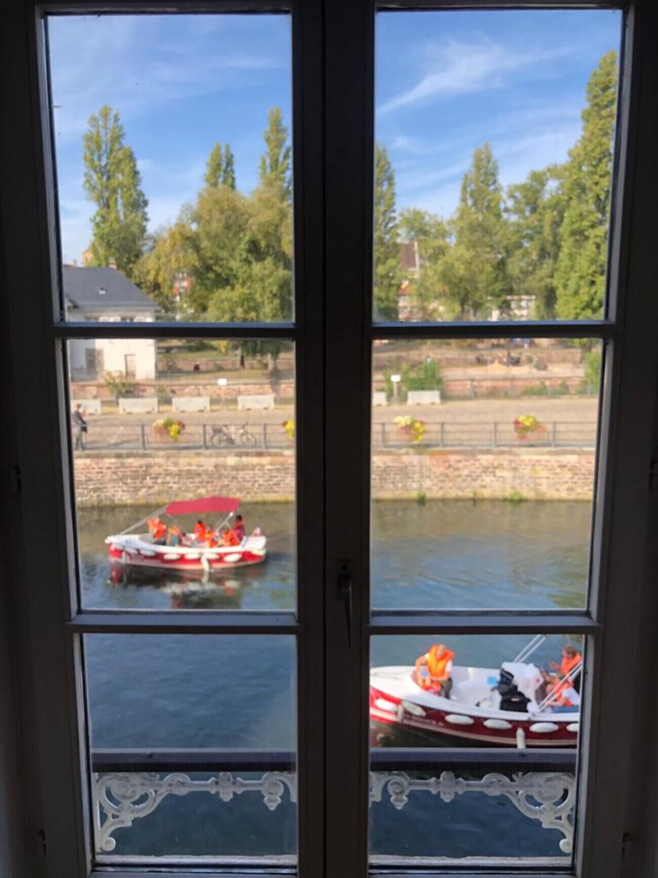 A view through a window with two panes, each showing a body of water with boats.