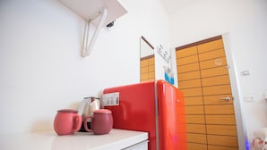 A kitchen with a red refrigerator, a white countertop, and a wooden door in the background. - Holiday Home Amalfitana Limone (Molina)