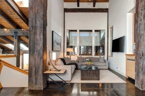 A modern living room with a sectional sofa, a coffee table, and a TV.
