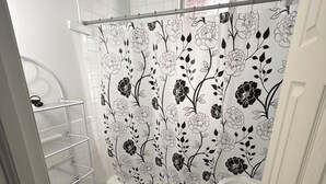 A small bathroom with a toilet, a sink, and a shower curtain with a floral pattern.