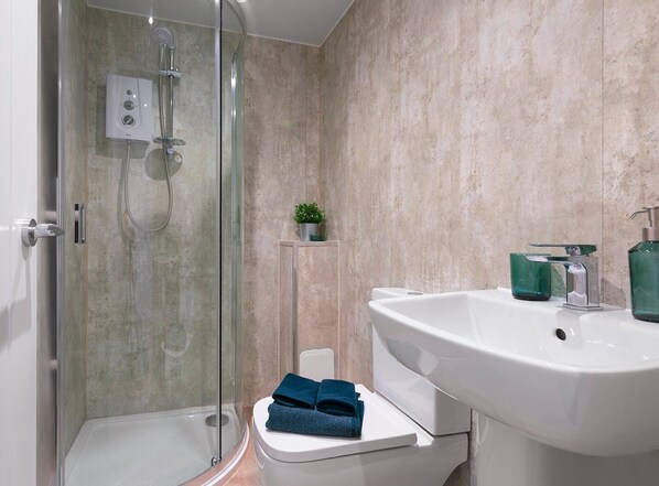 Regadera, toallas, papel de baño 