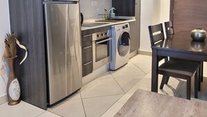 Eine moderne Küche mit Edelstahlgeräten, inklusive Backofen, Mikrowelle und Waschmaschine.
