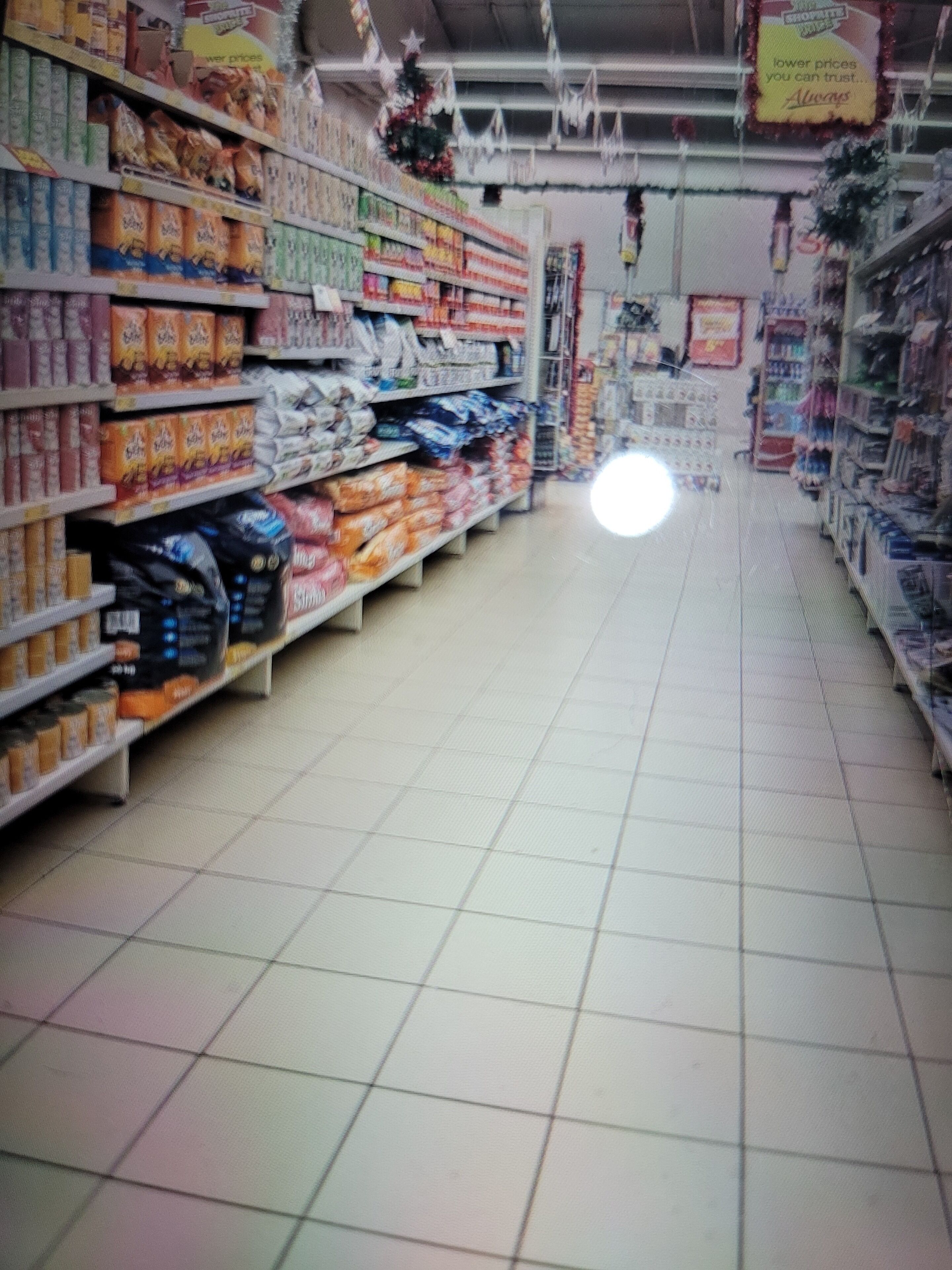 A grocery store aisle with shelves stocked with various products.