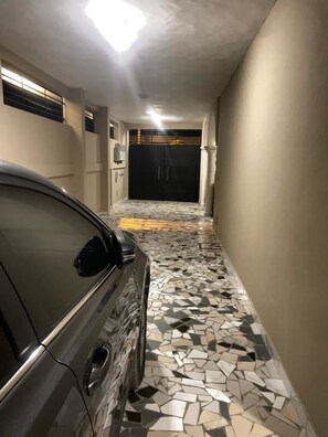 Leading to an entrance, this corridor offers a glimpse into the property's secure and secluded atmosphere.