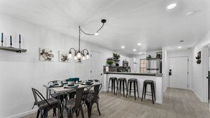 A modern kitchen with a central island, bar stools, and pendant lighting. - 5 minutes from strip|Pool|King|Stainless|300Mbps|4K|WD|BBQ (Branson)
