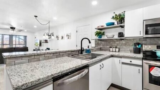 A modern kitchen with granite countertops, stainless steel appliances, and white cabinetry. - 5 minutes from strip|Pool|King|Stainless|300Mbps|4K|WD|BBQ (Branson)