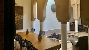 A dining area with a wooden table, black chairs, and decorative vases. - Riad Laksiba  (Marrakech)