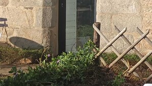 Ein Steinhaus mit einem großen Bogenportal, einer Metalttür und einem kleinen Fenster.