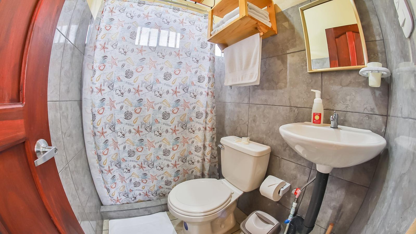 A bathroom with a toilet, sink, and shower curtain.