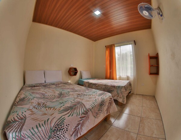 A room with two beds, a wooden ceiling, a window with curtains, and a wall-mounted shelf. - Chongos Place (La Fortuna)