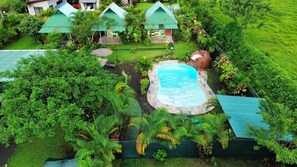 A resort with a swimming pool surrounded by lush greenery and multiple bungalow-style accommodations. - Chongos Place (La Fortuna)