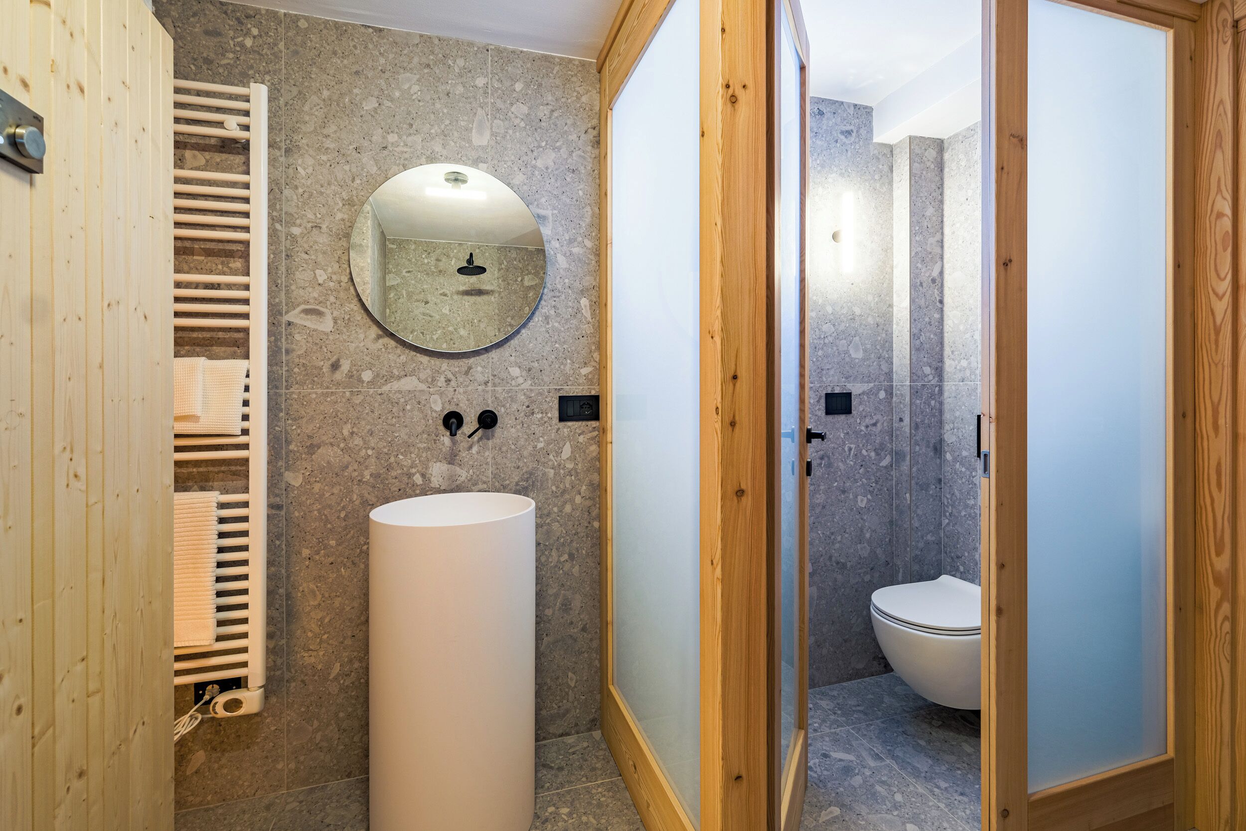 Une salle de bain moderne avec un grand lavabo, un miroir et un espace douche.