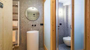 Une salle de bain moderne avec un grand lavabo, un miroir et un espace douche.