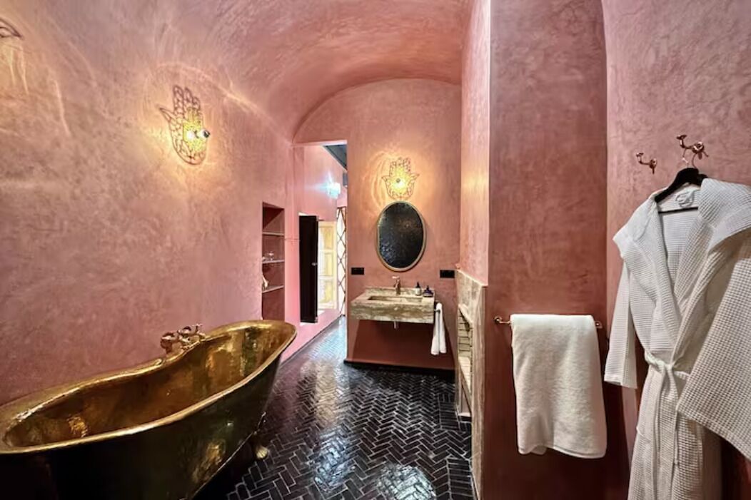 A bathroom with a freestanding bathtub, a sink with a mirror, and a towel rack.