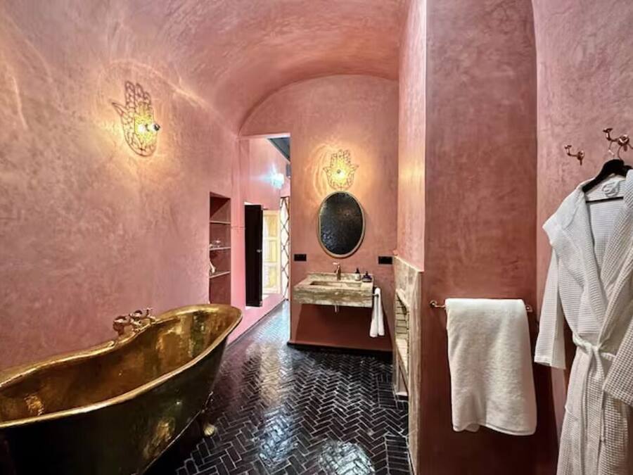 A bathroom with a freestanding bathtub, a sink with a mirror, and a towel rack.