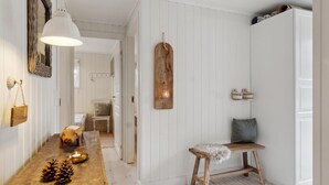 A hallway with a wooden bench, a hanging light fixture, and a rustic wall decor.