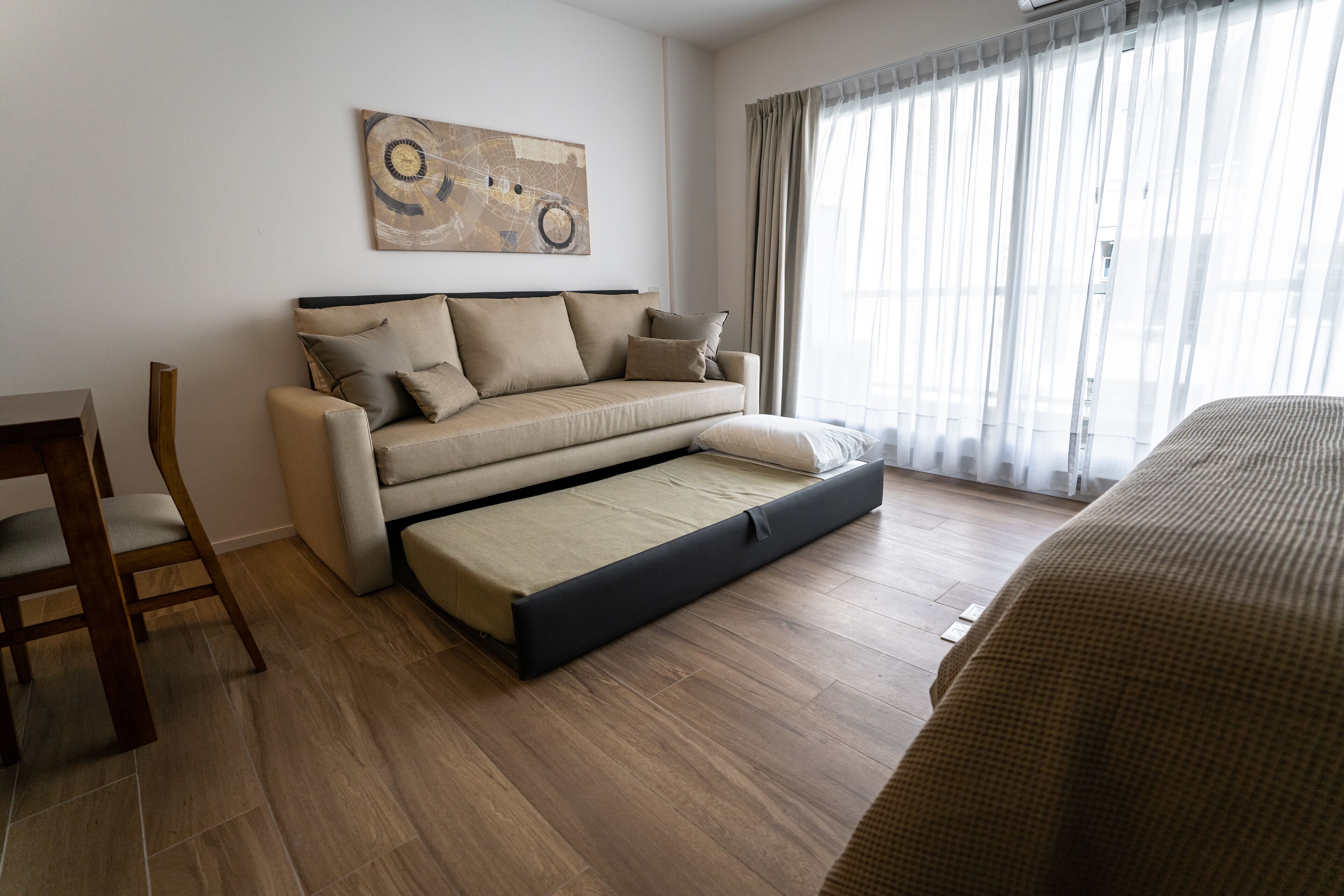 Een moderne woonkamer met een bank, een salontafel en een eethoek met een stoel.