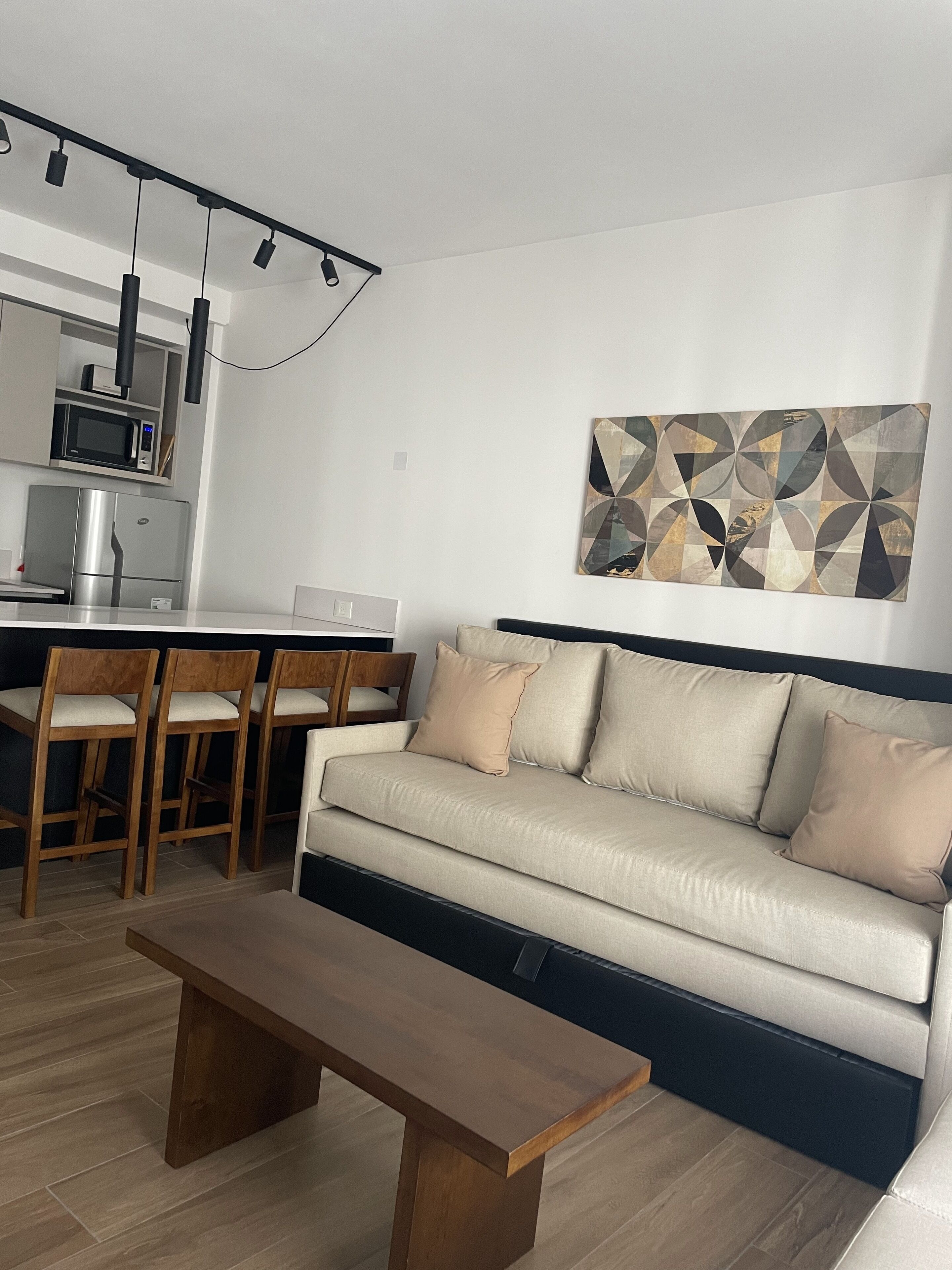 Uma sala de estar moderna com um sofá, uma mesa de centro e um espaço de jantar com cadeiras e uma mesa.