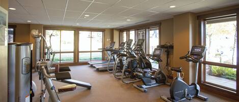 A gym with treadmills, elliptical machines, and weight machines.