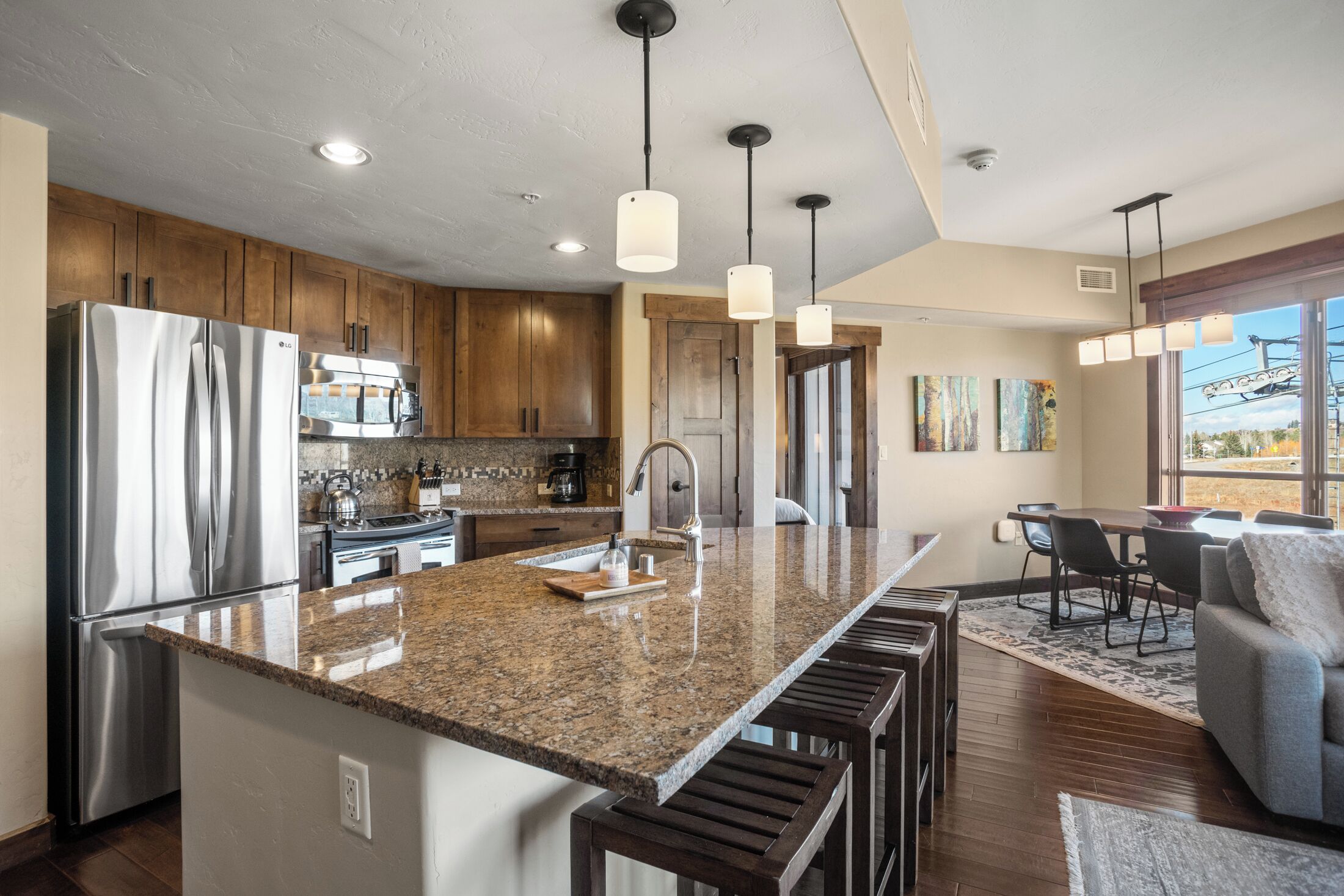 A modern kitchen with granite countertops, stainless steel appliances, and wooden cabinets.