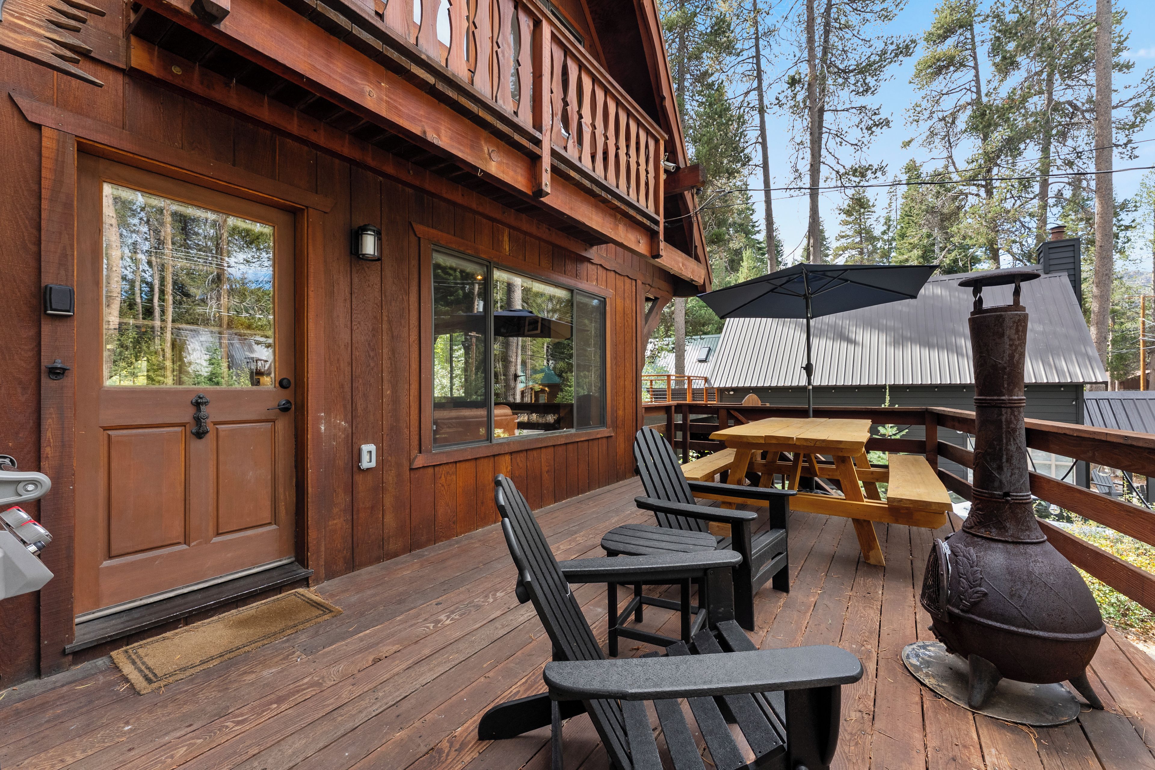 Eine Holzterrasse mit Sitzgelegenheiten und einem Grill.
