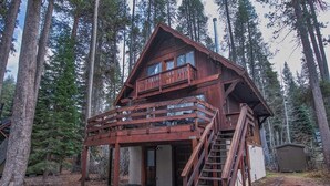 Eine Holzhütte mit Balkon und einer Treppe zum Eingang.