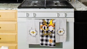 Une cuisine avec un four blanc, un four à micro-ondes placé au-dessus, et un pare-feu à motifs à pois.