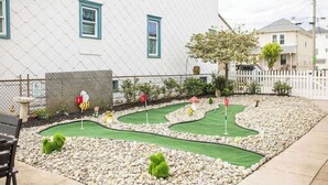 Un parcours de minigolf avec une maison en arrière-plan.