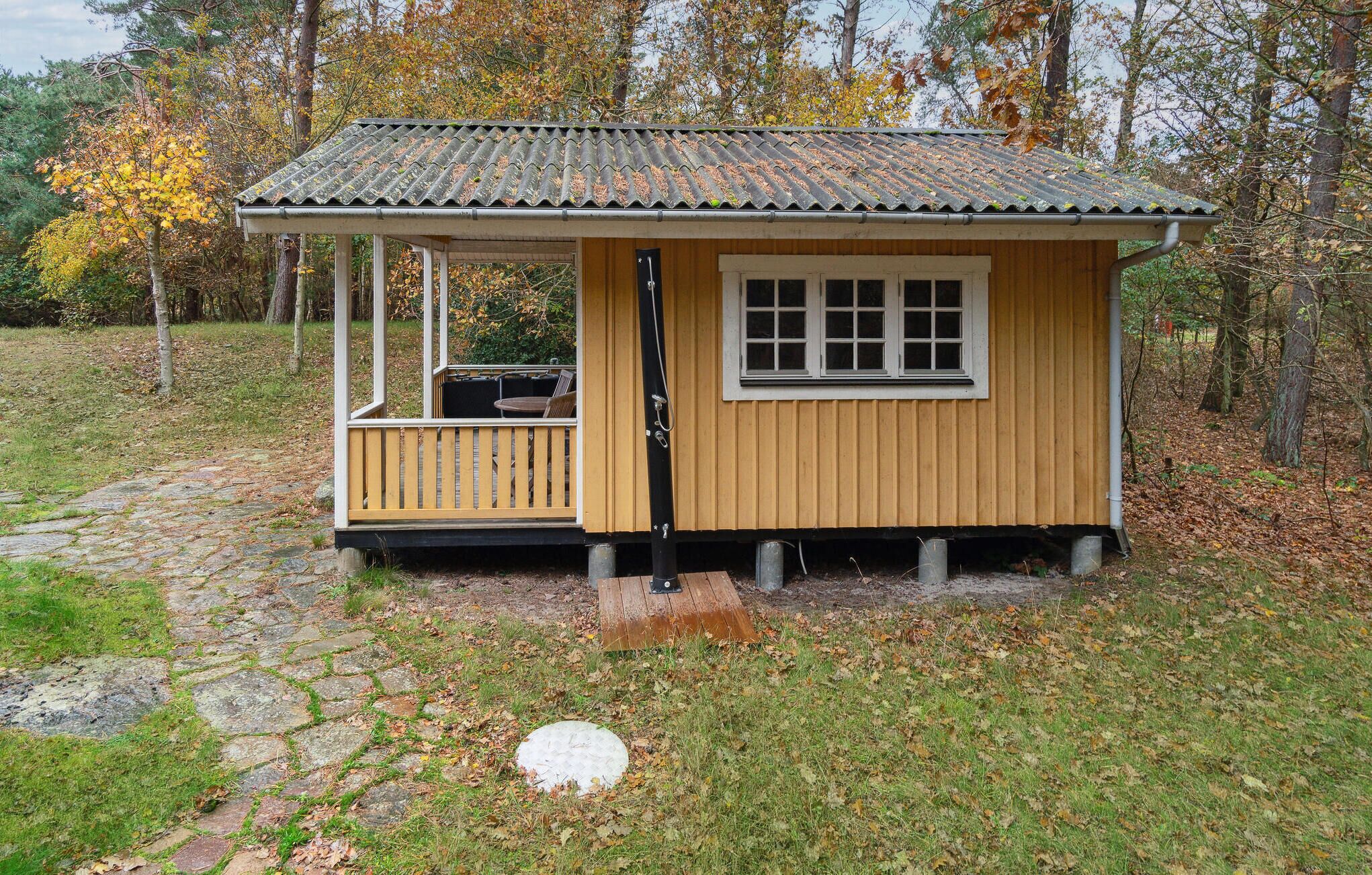 Une petite cabane en bois avec une véranda, une fenêtre et une porte.