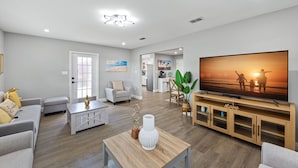 Uma sala de estar moderna com uma TV de tela plana, uma mesa de centro e um sofá.
